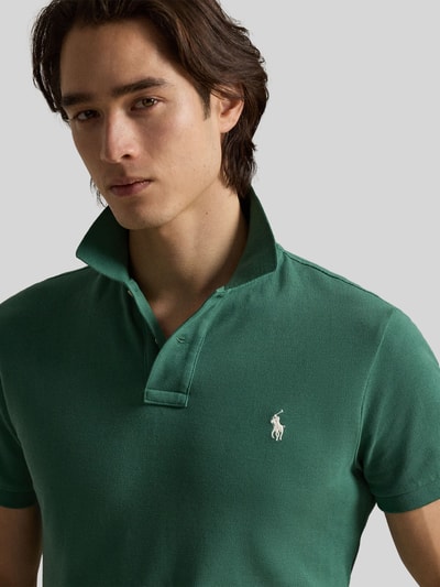 Männermodel trägt Regular Fit Poloshirt aus reiner Baumwolle von Polo Ralph Lauren in Grün, Piqué-Struktur, Logo-Detail, Nahaufnahme Oberkörper.