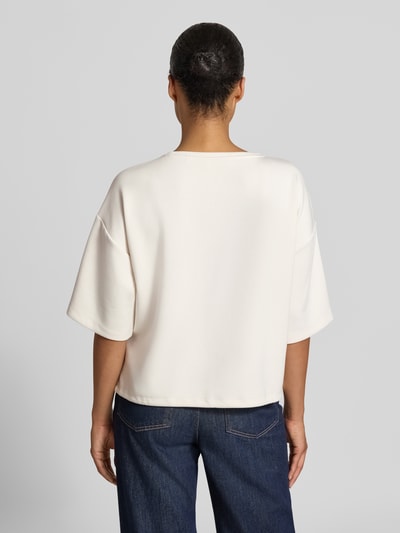 Frauenmodel trägt Relaxed Fit T-Shirt mit Statement-Print von Christian Berg Woman in Offwhite, elastischer Material-Mix, Ganzkörperansicht Rückansicht.