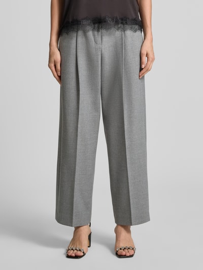 Frauenmodel trägt Regular Fit Bundfaltenhose mit Viskose-Woll-Anteil Modell 'SLOANNE' von SEDUCTIVE, graue Farbe, weite Passform, Nahaufnahme Unterkörper, Damen Bundfaltenhose von SEDUCTIVE.
