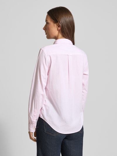 Frauenmodel trägt Hemdbluse aus Baumwolle mit Streifenmuster von GANT, gerader Schnitt, Langärmelig, Label-Detail, Ganzkörperansicht Rückansicht.