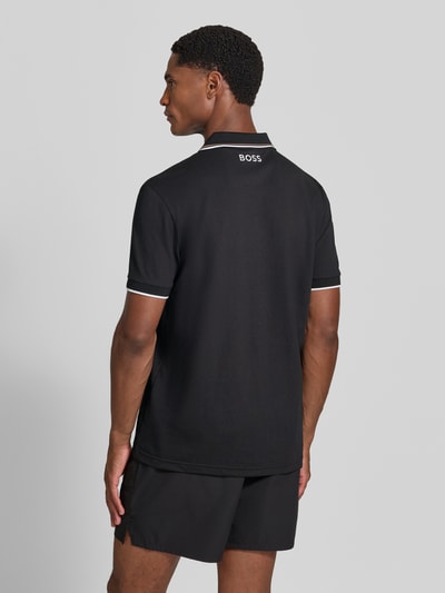 Męski model nosi czarną koszulkę polo Regular Fit Poloshirt aus Baumwoll-Mix model 'Paddy Pro' von BOSS Green, gładka faktura, widok całej sylwetki z tyłu