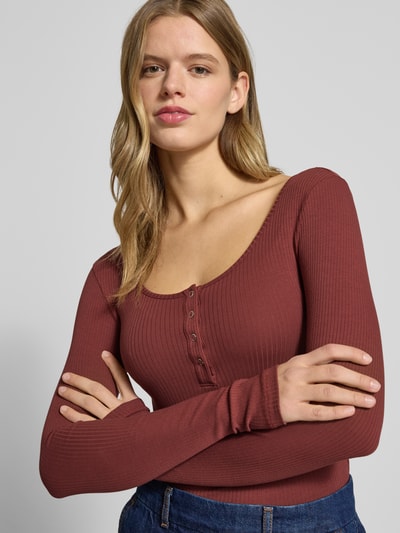 Kobiece modelka nosi Slim Fit Langarmshirt aus Baumwoll-Mix Modell 'KITTE' od Pieces, prążkowana faktura, jednolity kolor, paski, widok z przodu, zbliżenie na górną część ciała.