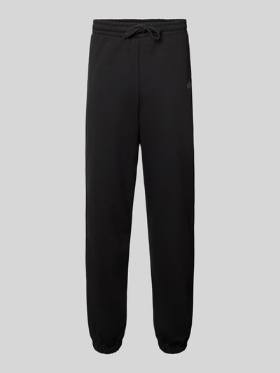 Produktfoto, spodnie dresowe Sweatpants mit Label-Print von Alpha Industries, czarny kolor, elastyczny pas z tunelem, mieszanka bawełny, luźny krój, wpuszczane kieszenie, nadruk z logo, długość wewnętrzna nogawki w rozmiarze M: 44 cm