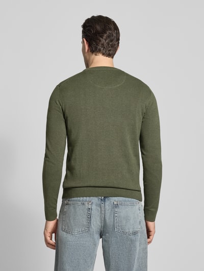 Männermodel trägt Regular Fit Strickpullover aus reiner Baumwolle von Tom Tailor in unifarbenem Melange-Grün, gerippte Bündchen, Ganzkörperansicht Rückansicht.