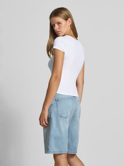 Vrouwenmodel draagt wit t-shirt met statement-stitching van REVIEW, katoenmix met biologisch katoen, nauwsluitend model, ronde hals, ruglengte maat S 51 cm, volledig van achteren te zien.