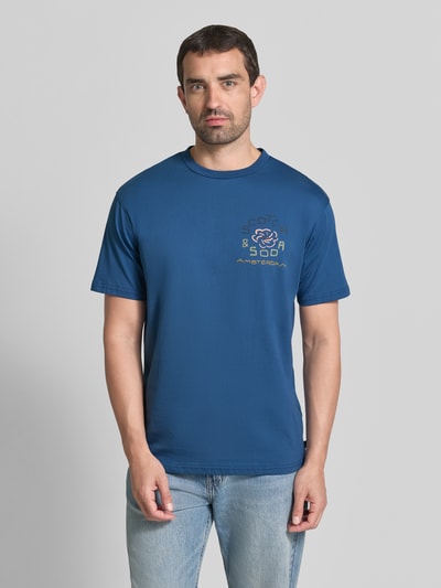 Männermodel trägt T-Shirt mit Label-Print und Rundhalsausschnitt van Scotch & Soda in blauw, puur katoen, regular fit, ruglengte maat M 72 cm, Ganzkörperansicht van voren
