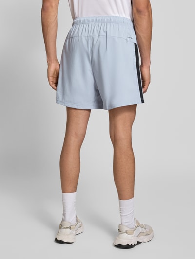Männermodel trägt Shorts mit Logo-Print und Reißverschlusstaschen von adidas Training in Hellgrau, Lockerer-Schnitt, Elastischer-Bund, Bundweite bei Größe M: 33 cm, Innenbeinlänge 15 cm, Ganzkörperansicht Rückansicht.
