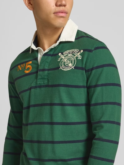 Mannenmodel draagt Rugby-Shirt mit Polokragen im Allover-Look van Superdry in groen met donkerblauwe strepen, puur katoen, regular fit, knoopsluiting, shirt met lange mouwen, ruglengte bij maat M 70 cm, Nahaufnahme Oberkörper.