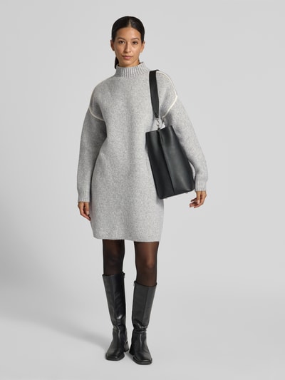 Frauenmodel trägt Regular Fit Strickkleid mit Kontraststreifen von VERO MODA, grau, Strickoptik, knielang, Mock Neck, Ganzkörperansicht von vorne.