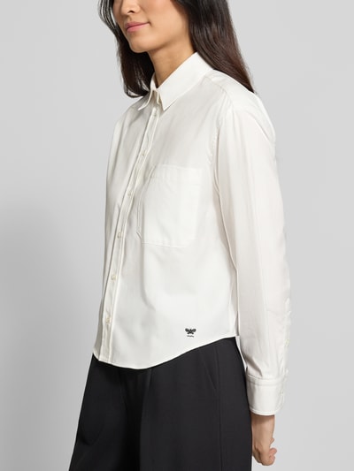 Vrouwenmodel draagt witte loose fit blouse met lange mouwen van katoen, model 'NUORO' van Weekend Max Mara, dames. Halfzijdige opname bovenlichaam.