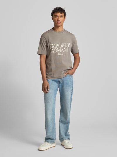 Männermodel trägt Herren T-Shirt mit Label-Stitching von Emporio Armani in Grau, reine Baumwolle, Regular-Fit, gerippter Rundhalsausschnitt, Ganzkörperansicht von vorne.