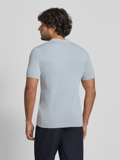 Männermodel trägt hellblaues Slim Fit Poloshirt Modell 'Triton' von Drykorn mit Strukturmuster aus reiner Baumwolle, Rückansicht Ganzkörperansicht.