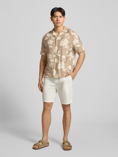 Männermodel trägt Regular Fit Freizeithemd aus Viskose-Mix von REVIEW, beige mit weißen Blumen, Reverskragen, 1/2-Arm, Knopfleiste, Ganzkörperansicht von vorne. Rückenlänge bei Größe M: 74 cm, Schulterbreite: 54 cm, Ärmellänge: 30 cm.