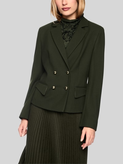 Frauenmodel trägt Slim Fit Blazer mit Reverskragen und Pattentaschen von Marc Cain in Dunkelgrün, Material-Mix mit Viskose, Zweireiher, Ganzkörperansicht von vorne.