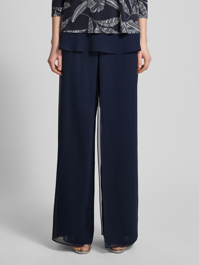 Kobiece modelka nosi Wide Fit Stoffhose im semitransparentem Design od Vera Mont, ciemnogranatowe, szerokie nogawki, lekko prześwitujący materiał, szerokość w rozmiarze 36: 29 cm, długość wewnętrzna nogawki w rozmiarze 36: 86 cm, widok na całe ciało z przodu.