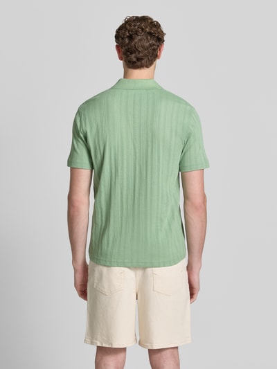Männermodel trägt Regular Fit Poloshirt aus Baumwoll-Mix Modell 'TRAVIS' von SELECTED HOMME, Optik: Unifarben, Struktur, Ganzkörperansicht Rückansicht.