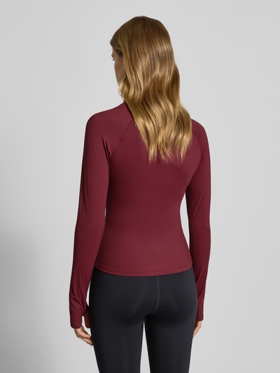 Vrouwenmodel draagt Slim Fit Sweatjacke met Stehkragen Modell 'Yoga' van Gina Tricot in bordeauxrood, elastische mix, rugaanzicht full body.