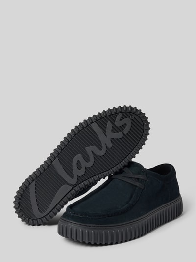 Produktfoto, Bootsschuhe aus beschichtetem Leder Modell 'Torhill' von Clarks in Schwarz, abgerundete Form, profilierte Sohle, Schnürung, 3 cm Absatz, 7 cm Schafthöhe, 11 cm Schaftweite, grauer Hintergrund.