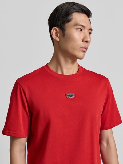 Männermodel trägt T-Shirt mit Label-Detail von Antony Morato in Rot, reine Baumwolle, Regular Fit, Nahaufnahme Oberkörper.