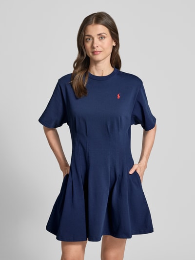Kobieta modelka nosi Leicht ausgestelltes Sweatkleid aus reiner Baumwolle von Polo Ralph Lauren, melanż, krój lekko rozkloszowany, długość mini, okrągły dekolt, wyhaftowane logo, zakładane fałdy, krótki rękaw, wykończenie materiału: dzianina dresowa, materiał: czysta bawełna, widok całego ciała z przodu.