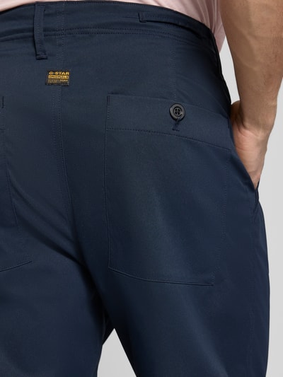Männermodel trägt Straight Fit Chino mit Bundfalten von G-Star Raw in Dunkelblau, elastischer Material-Mix, Detailaufnahme Rückansicht.