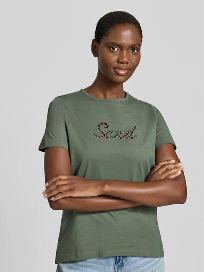 Kobiece model nosi damski t-shirt Regular Fit T-Shirt aus reiner Baumwolle Modell 'MIRANDA' von Vero Moda, efekt: jednolity kolor, haft angielski, okrągły dekolt, krótki rękaw, dżersej, 100% bawełna, ujęcie całej sylwetki z przodu.