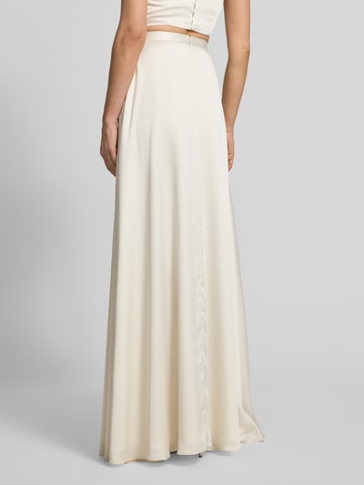 Frauenmodel trägt Relaxed Fit Abendkleid mit Gehschlitz von Jake*s Cocktail in Creme, Satin mit Spaghettiträgern, Ganzkörperansicht Rückansicht.