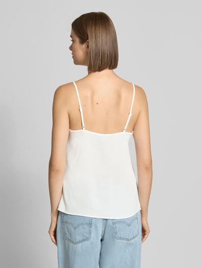 Młodzieżowy model nosi białą bluzkę o luźnym kroju z obszyciem koronką, Loose Fit Blusentop mit Spitzenbesatz Model 'TIFFANY' von PIECES, widok całej sylwetki od tyłu.