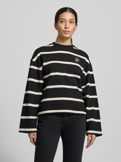 Frauenmodel trägt Relaxed Fit Sweatshirt aus Baumwoll-Mix von Tommy Hilfiger mit schwarz-weißem Allover-Streifendesign, Logo-Stitching, Rundhalsausschnitt und langen Ärmeln, Sweat-Material, Ganzkörperansicht von vorne.