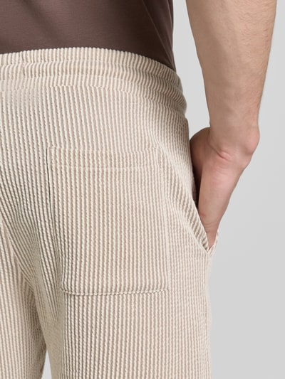 Männermodel trägt Shorts mit elastischem Bund und Kordelzug von MCNEAL aus Baumwoll-Mix in Beige, Detailaufnahme Rückansicht. Loose-Fit, Bundweite 41 cm, Innenbeinlänge 23 cm, sichtbare Struktur und Streifenmuster.