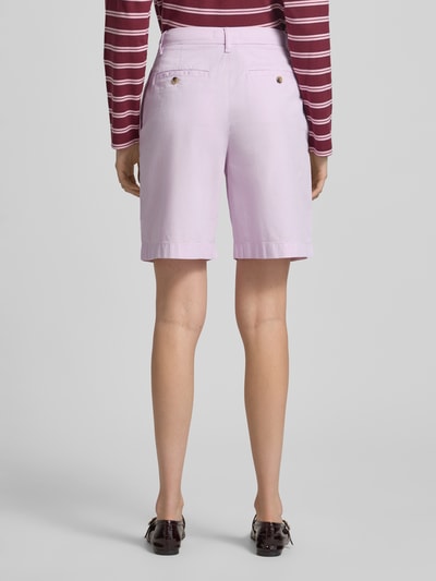 Frauenmodel trägt Regular Fit Chino-Shorts aus Baumwoll-Lyocell-Mix von Tommy Hilfiger, efekt: jednolity kolor, wyhaftowane logo, wpuszczane kieszenie boczne i z tyłu, zapięcie na guzik i zamek błyskawiczny, mieszanka bawełny i lyocellu, krój regular fit, Ganzkörperansicht Rückansicht.