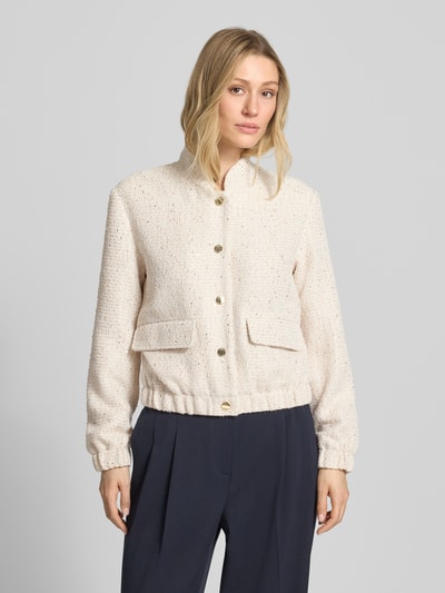 Frauenmodel trägt Regular Fit Kurzblazer mit Paillettenbesatz von s.Oliver BLACK LABEL in schimmernder Optik, Bouclé-Material, College-Kragen, Langarm, Druckknopfleiste, elastischem Rumpfabschluss, Pattentaschen, Nahaufnahme Oberkörper.