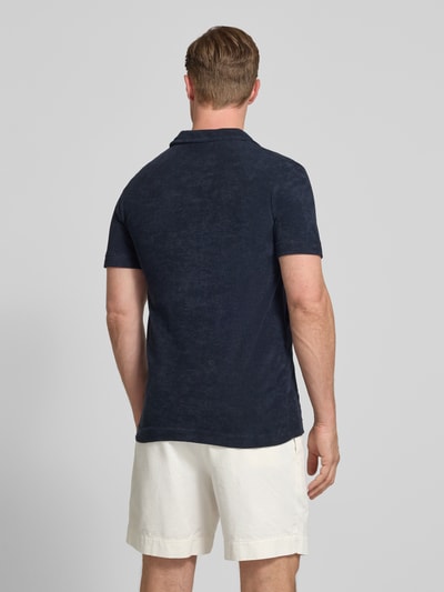 Mężczyzna nosi Relaxed Fit Poloshirt mit V-Ausschnitt von Lindbergh z mieszanki bawełny, frota, brustasza, długość tyłu 76 cm, widok całej sylwetki od tyłu.