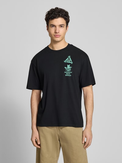 Męski model trägt T-Shirt mit Print und Rundhalsausschnitt von Edwin, czarna bawełna, krój relaxed fit, długość tyłu w rozmiarze M: 72 cm, Ganzkörperansicht von vorne.