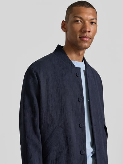 Männermodel trägt donkerblauwe blouson van structuurmix van katoen en lyocell Regular Fit Blouson aus Baumwoll-Lyocell-Mix Modell 'UKASHI263X-H' van HUGO, heren bomberjack, Nahaufnahme Oberkörper.