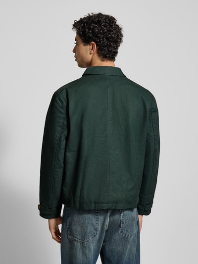 Männermodel trägt Jacke mit Label-Stitching und Eingrifftaschen von BLKVIS aus reine Baumwolle, Regular-Fit, dunkelgrün, Ganzkörperansicht Rückansicht.