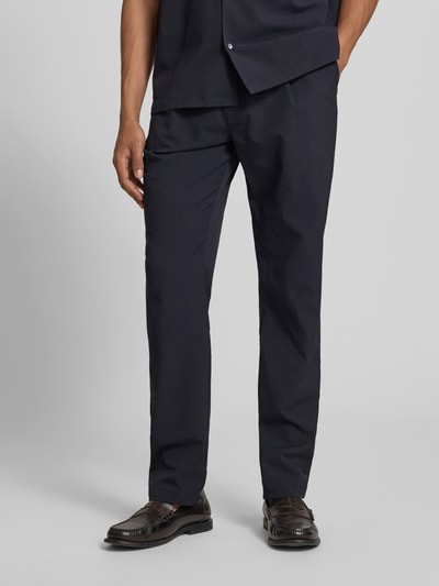 Männermodel trägt Stoffhose mit elastischem Bund von Closed, dunkel, Strukturmuster, Eingrifftaschen, Relaxed-Fit, Nahaufnahme Unterkörper.