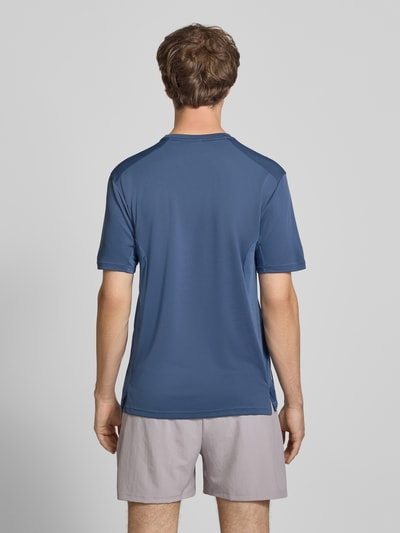 Männermodel trägt Regular Fit T-Shirt mit Logo-Print Modell 'TECH APP TEE' von adidas Training in Blau, Ganzkörperansicht Rückansicht.