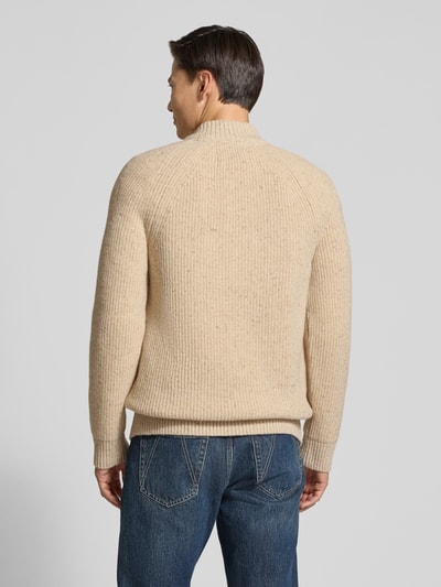 Mannelijk model draagt Troyer aus Woll-Mix mit Raglanärmeln van BARBOUR in beige breipatroon met geribde boorden, geheelopname achteraan.