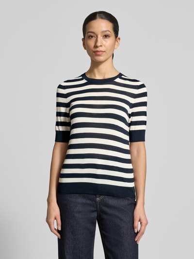 Frauenmodel trägt Shaped Fit Strickpullover aus reiner Schurwolle Modell 'Farbella' von BOSS, Optik: Unifarben, Muster: Gestreift, feine Struktur mit Crew Neck, Kurzarm, Gerippt, Materialverarbeitung: Feinstrick, Ganzkörperansicht von vorne.
