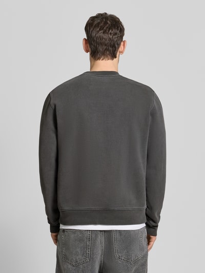 Männermodel trägt dunkelgraues Sweatshirt mit Logo-Print Modell 'JOEL' von Samsøe Samsøe; Relaxed Fit, Baumwoll-Mix, Rückansicht Ganzkörperansicht.