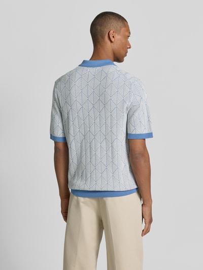 Männermodel trägt Slim Fit Poloshirt in Strick-Optik Modell 'Blake' von Jack & Jones Premium, Reine Baumwolle, Kurzärmelig, Rückenlänge 72 cm, helle Grundfarbe mit geometrischem Muster, Kontrastbündchen in Blau, Ganzkörperansicht Rückansicht.
