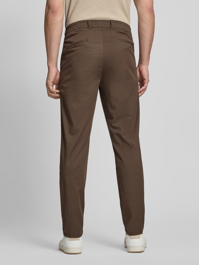 Męski model nosi chinosy Chino mit Eingrifftaschen Modell 'Tino' von Brax, mieszanka bawełny i elastanu, krój comfort fit, plisowane, wpuszczane kieszenie, szerokość w rozmiarze 32/32: 42 cm, długość wewnętrzna nogawki: 77 cm, widok całej sylwetki z tyłu.
