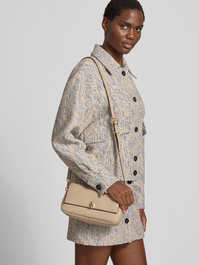 Frauenmodel trägt Shoulder Bag mit Logo-Detail von Tory Burch, beige, Hauptfach mit Überschlag, Magnetverschluss, Ganzkörperansicht von vorne.