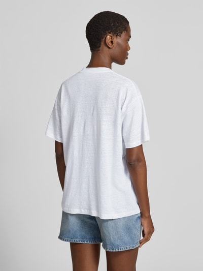 Vrouwenmodel draagt Regular Fit T-shirt uit zuiver linnen van Anine Bing, ronde hals, gestikt logo, met korte mouwen, ruglengte maat S 63 cm, Ganzkörperansicht Rückansicht.