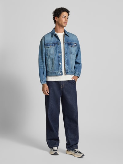 Männermodel trägt Jeansjacke mit Brusttaschen und Label-Detail von Calvin Klein Jeans aus Reine Baumwolle im Relaxed-Fit, Ganzkörperansicht von vorne.