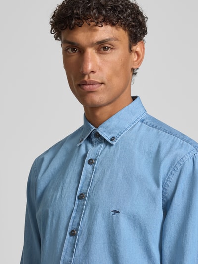Männermodel trägt Regular Fit Freizeithemd mit Button-Down-Kragen von Fynch-Hatton, bawełna, tkanina stylizowana na denim, wyhaftowane logo, szerokość ramion w rozmiarze M: 47 cm, długość tyłu w rozmiarze M: 50 cm, długość rękawów w rozmiarze M: 66 cm, koszula casualowa, krój regular fit, koszula męska, imitacja denimu, kołnierzyk typu button down, haft, jasnoniebieski, gładka faktura. Nahaufnahme górnej części torsu.