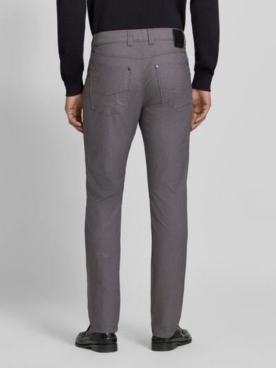 Männermodel trägt Straight Fit Hose aus Baumwoll-Mix Modell 'Yarn' von bugatti in Grau mit 5-Pocket-Design, Ganzkörperansicht Rückansicht.
