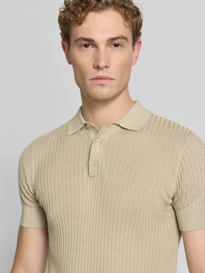 Männermodel trägt Slim Fit Poloshirt aus Viskose-Mix mit Leinen-Anteil von Antony Morato in Strick-Optik, beige, Nahaufnahme Oberkörper. Kontext: Herren Poloshirt, Polokragen, Rückenlänge bei Größe M 70 cm.