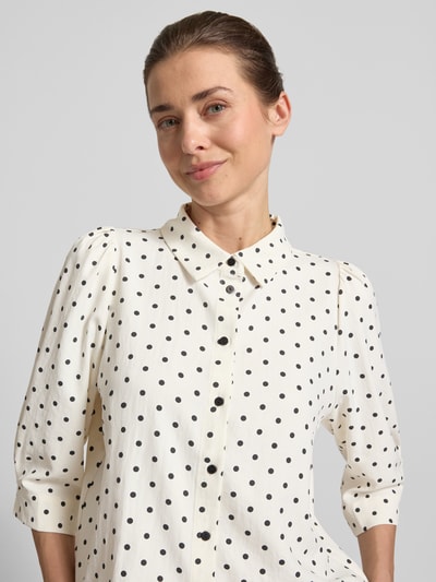 Frauenmodel trägt Regular-Fit Damen Bluse mit 3/4-Arm Modell 'Bono' von LOLLYS LAUNDRY, Allover-Look mit schwarzen Punkten, Nahaufnahme Oberkörper. Rückenlänge bei Größe S: 57 cm, Ärmellänge: 43 cm.